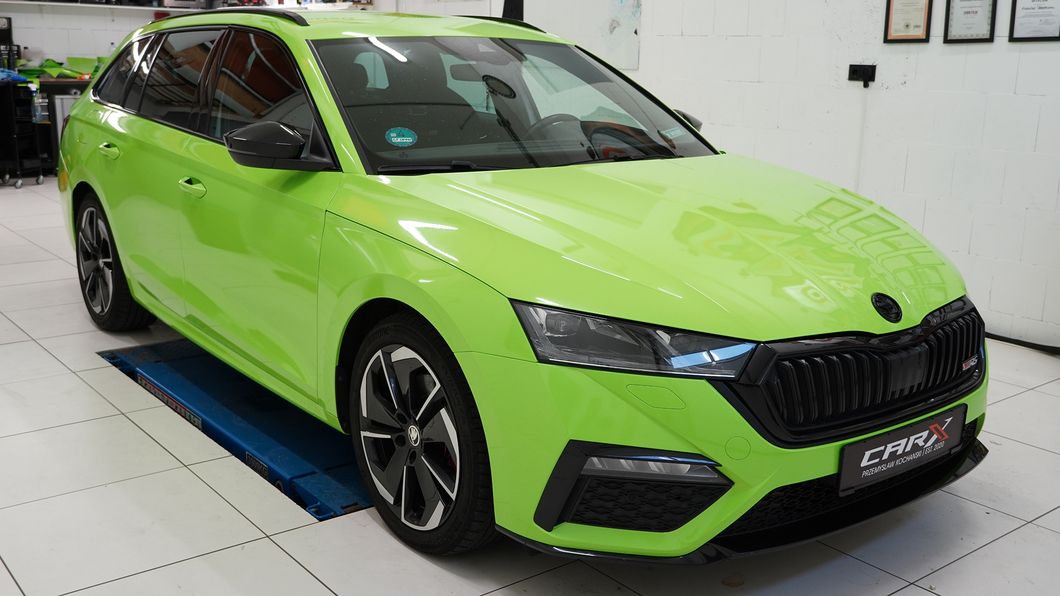 Leuchtend grüner Škoda Octavia Kombi steht in einer Werkstatt auf einer Hebebühne