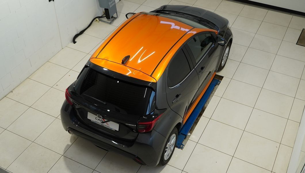 Schwarzer Mazda 2 mit oranger Dachfolierung